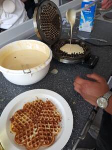 Waffelbacken für einen guten Zweck: Die Einnahmen aus dem Verkauf kommen der Bahnhofsmission zugute. Zuvor hat die Klasse dort schon für die Besucher Waffeln gebacken.